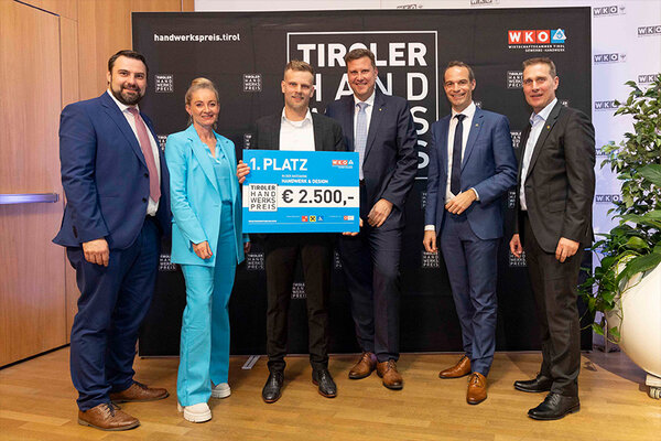 Gewinner der Kategorie mit Scheck in der Hand. Links und rechts Funktionäre der Wirtschaftskammer Tirol.