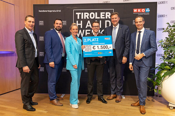 Gewinner mit Scheck, links und rechts Funktionäre der Wirtschaftskammer Tirol