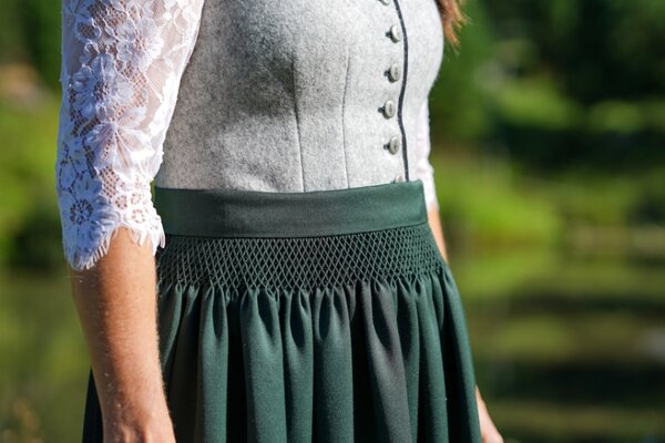 Dirndl in grau und grüner Schürze mit weißbestickter Bluse
