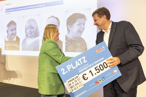 Funktionär überreicht Frau einen Scheck