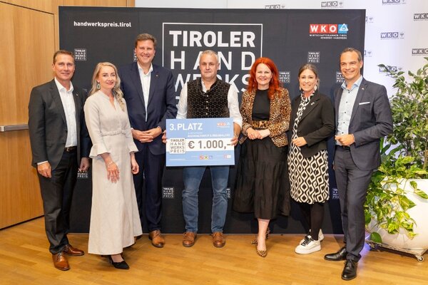 Gewinner mit Scheck, links und rechts Funktionäre der Wirtschaftskammer Tirol