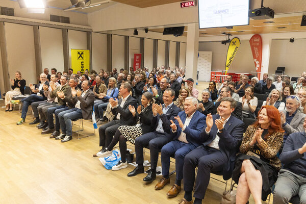 Menschen in einem großen Saal klatschen 