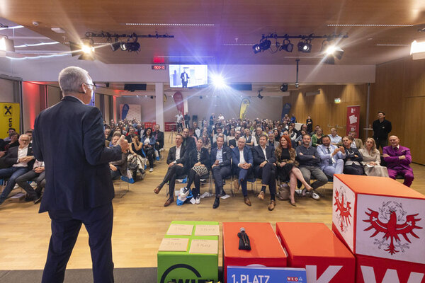 Ein Mann hält eine Rede vor einem großen Publikum und fesselt die Zuhörer mit seiner Ansprache.