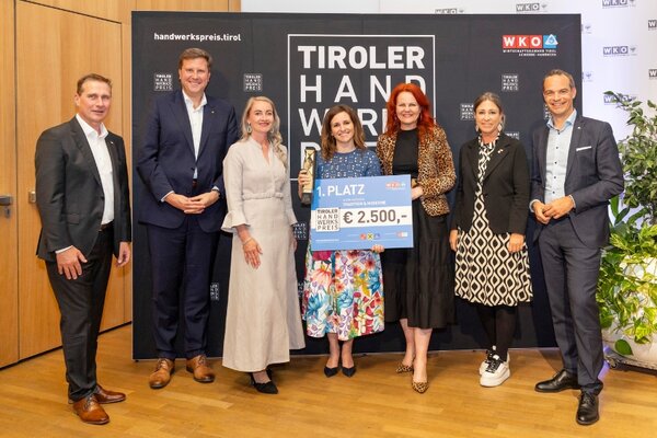 Gewinner mit Scheck, links und rechts Funktionäre der Wirtschaftskammer Tirol
