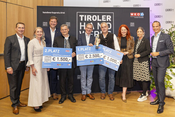 Eine Gruppe von Menschen hält stolz ihre Schecks in die Höhe und zeigt ihre Freude über den Gewinn in der Kategorie Nachhaltigkeit & Regionalität.