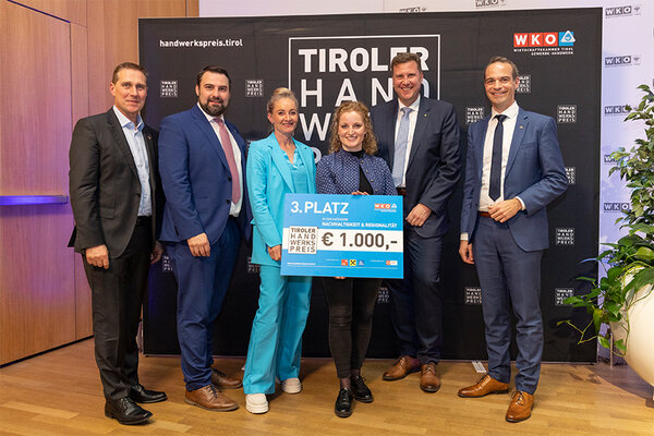 Gewinnerin mit Scheck und Funktionären der Wirtschaftskammer Tirol