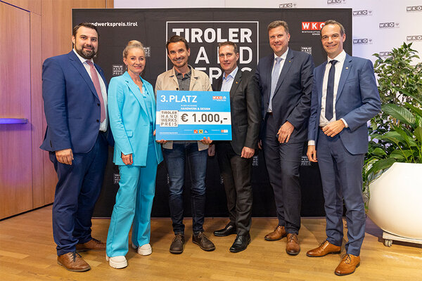 Gewinner mit Scheck, links und rechts Funktionäre der Wirtschaftskammer Tirol
