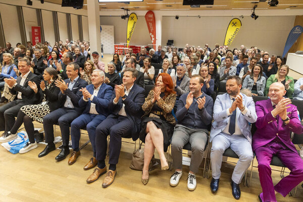 Menschen in einem großen Saal klatschen 
