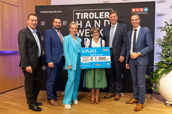 Gewinner mit Scheck, links und rechts Funktionäre der Wirtschaftskammer Tirol