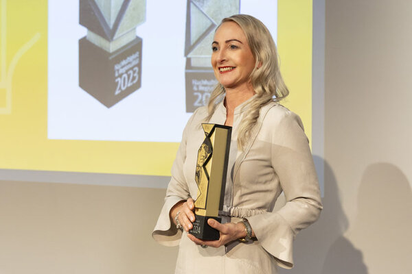 Funktionärin hält Pokal in der Hand 