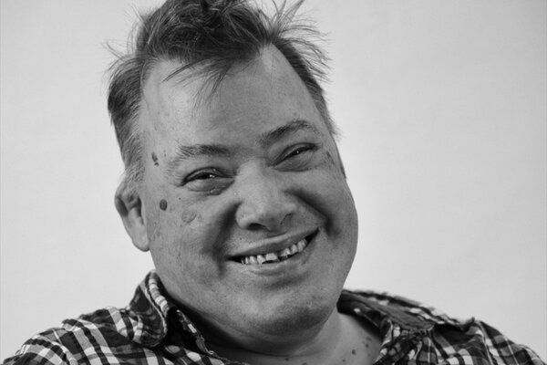 Portrait von lachendem Mann mit Down-Syndrom
