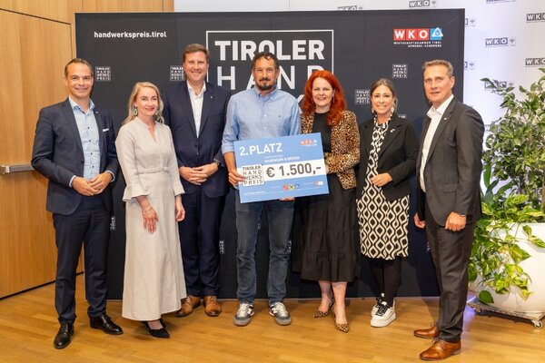 Gewinner mit Scheck, links und rechts Funktionäre der Wirtschaftskammer Tirol