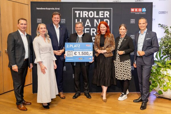 Gewinner mit Scheck, links und rechts Funktionäre der Wirtschaftskammer Tirol