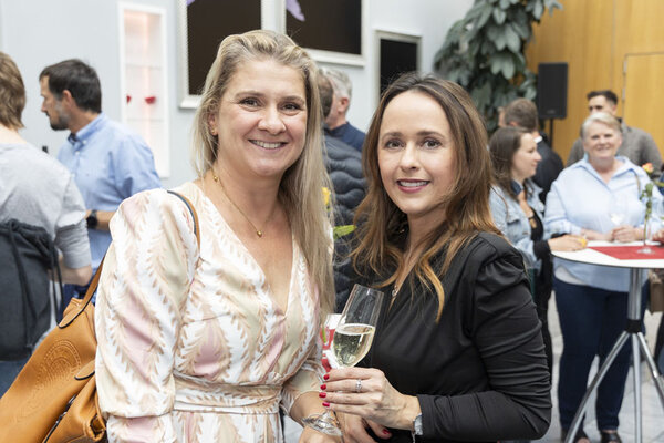 Zwei Frauen. Eine hält ein Glas Prosecco in der Hand