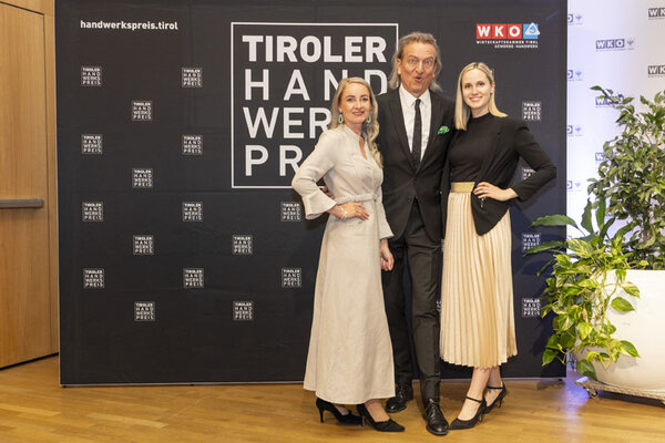 Funktionäre der Wirtschaftskammer Tirol posieren vor einer Logowand 
