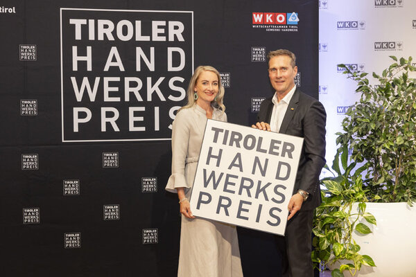 Funktionäre halten das Tiroler Handwerkspreis Logo in der Hand