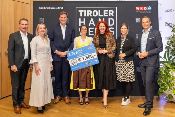 Gewinner mit Scheck, links und rechts Funktionäre der Wirtschaftskammer Tirol
