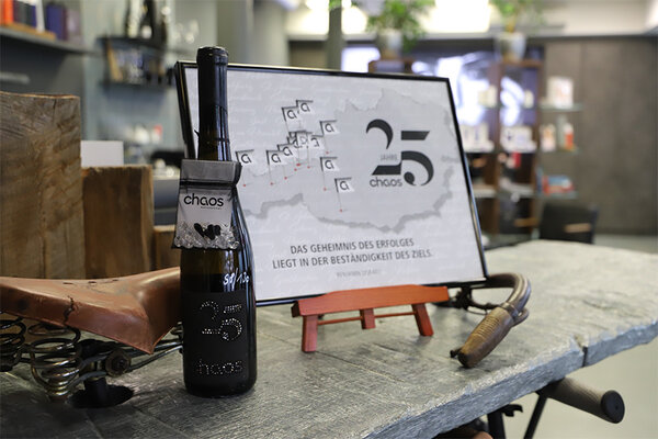 Ein gedeckter Tisch mit einer Flasche Wein und einem dekorativen Bild im Hintergrund.