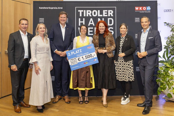 Die Gewinnerin hält stolz ihren Scheck und Pokal in die Höhe und zeigt ihre Freude über den 2. Platz in der Kategorie Tradition & Moderne.